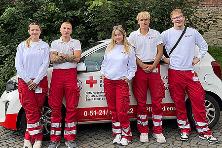 2026-07-27_DRK-Team_IMG_9029.jpg Junge Menschen in Einsatzkleidung vor einem DRK-PKW